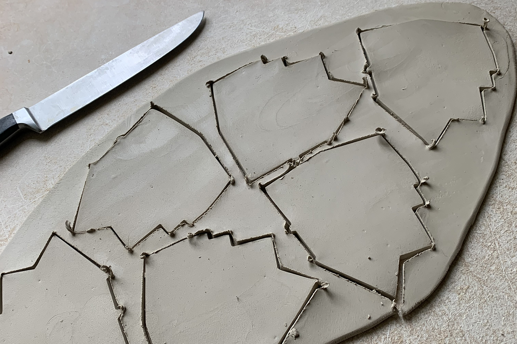Hand-cut clay shapes being prepared for firing